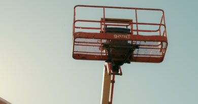 Orange boom lift basket against a clear sky